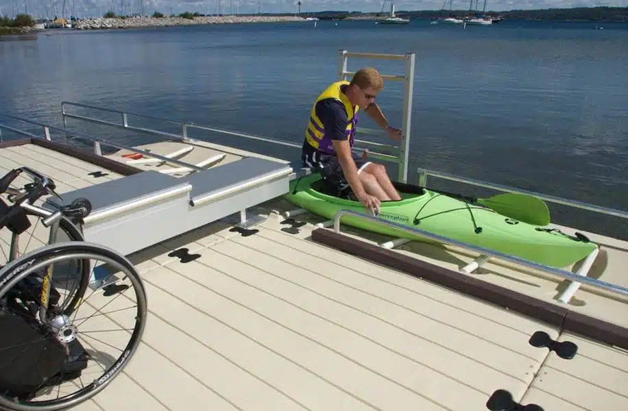A man enters a kayak using the Nor Col EZ dock boat entry system